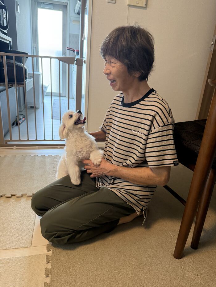 祖母に抱っこされて立ち上がるマルちゃん